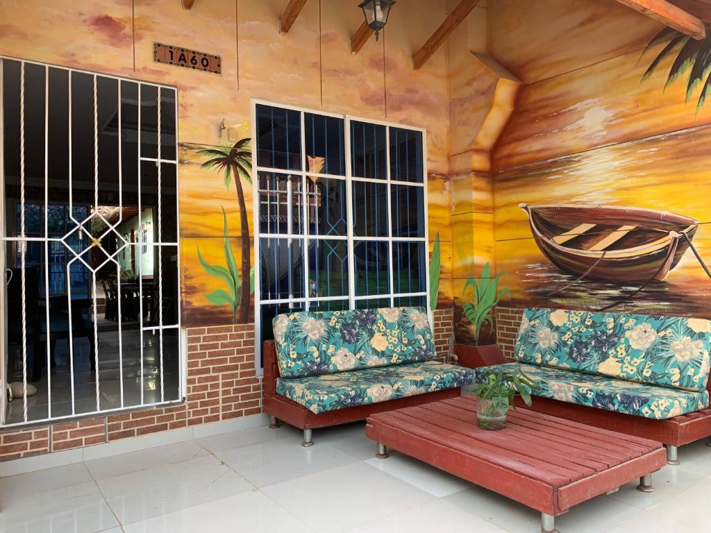 Hostal Buena Vida في تاجانجا: غرفة بها أريكتين ولوحة على الحائط