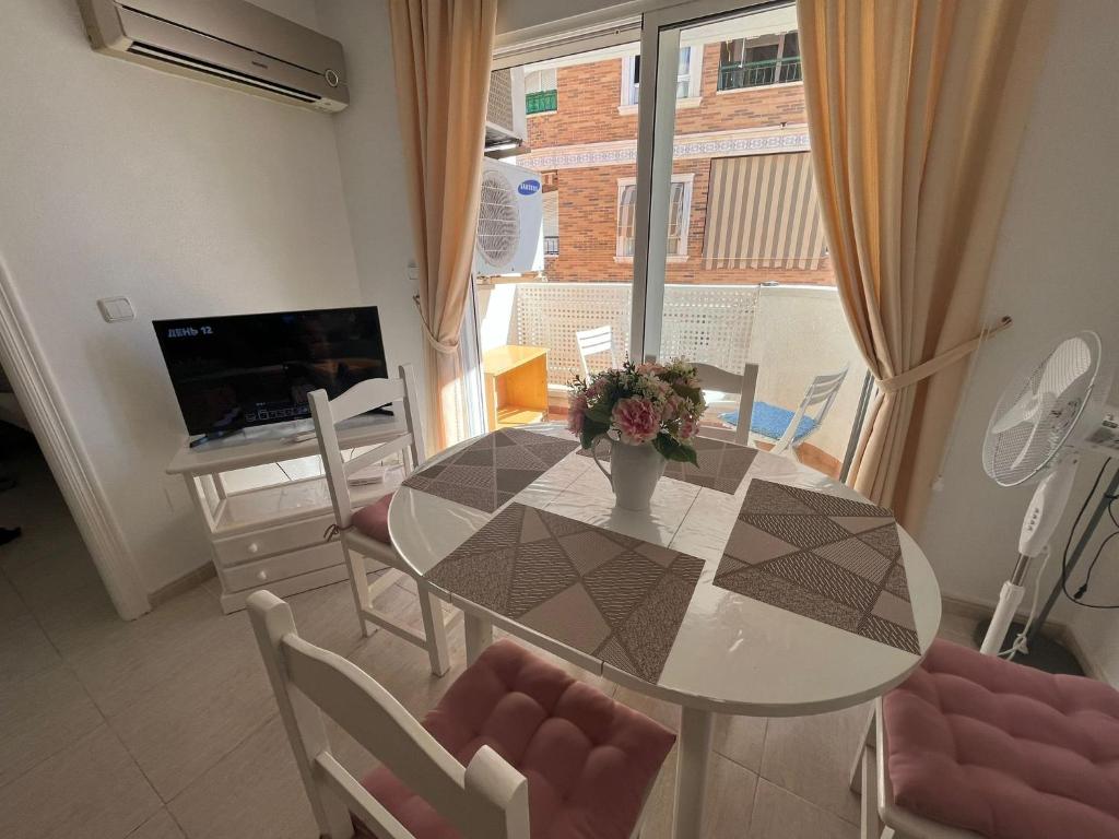 a dining room with a glass table and chairs at Ferienwohnung Torrevieja España in Torrevieja