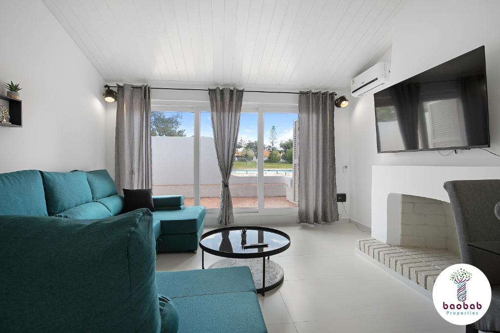 un soggiorno con divano blu e tavolo di Villa Sereno ad Albufeira
