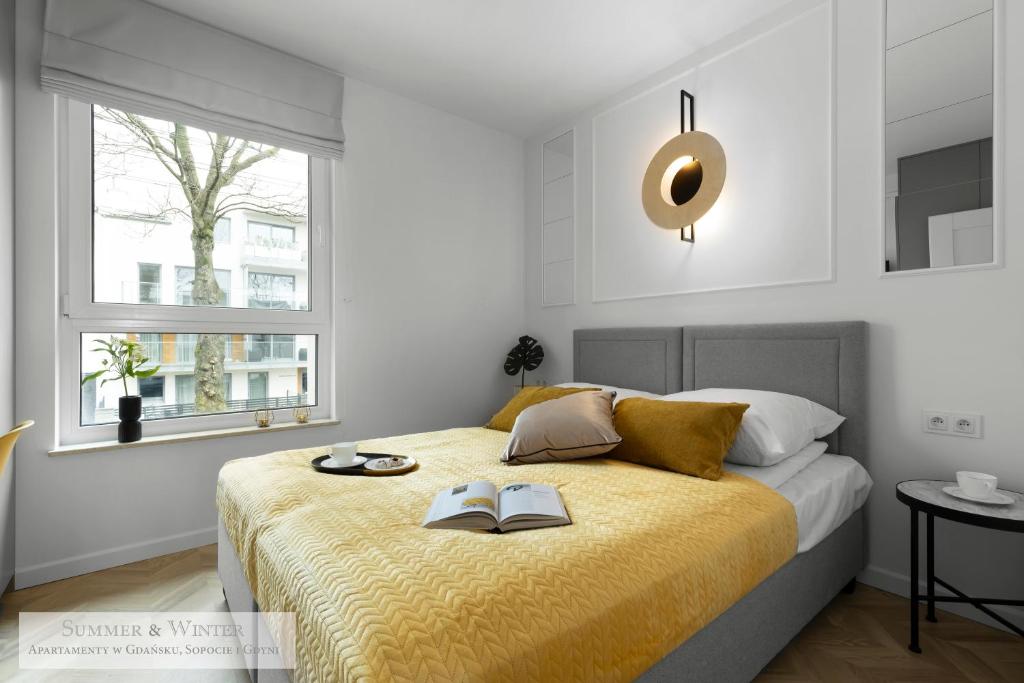 a bedroom with a bed with two books on it at Unique Luxury Butterfly & Bike Apartments, Gdynia Orłowo, 15 w pełni wyposażonych mieszkań, z dodatkową sypialnią, windą i płatnym parkingiem, wysoki standard SummerWinter in Gdynia