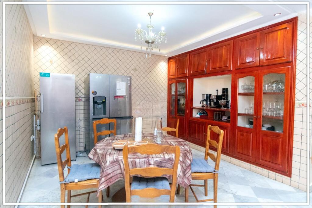 uma sala de jantar com uma mesa e um frigorífico em Fabuleuse Villa Marrakchi em Marrakech