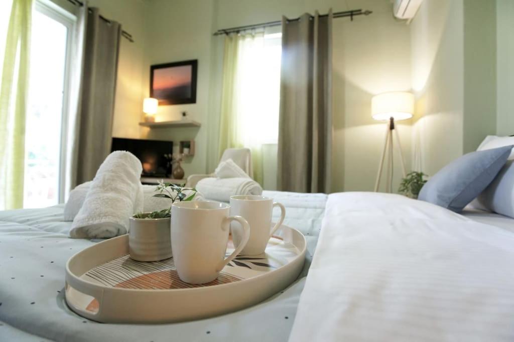 a tray with two coffee cups on a bed at The Green House With Υard in Piraeus