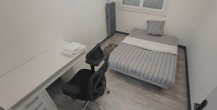 um quarto com uma secretária, uma cama e uma cadeira em Chambre dans Appartement - Grenoble, France à 8 min du centre-ville em Grenoble