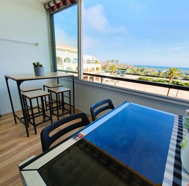 a balcony with a pool and a table and chairs at Superbe vue sur mer à Sète in Sète