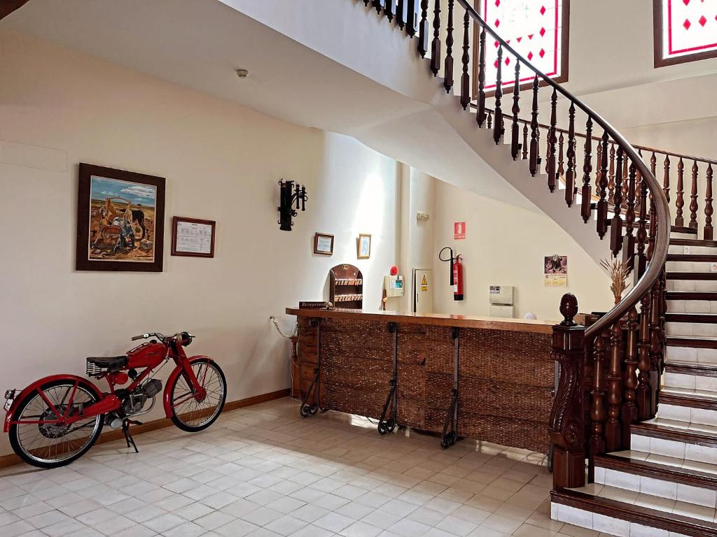 una bicicleta estacionada en una habitación con una escalera en Hotel A Posada, en Tembleque