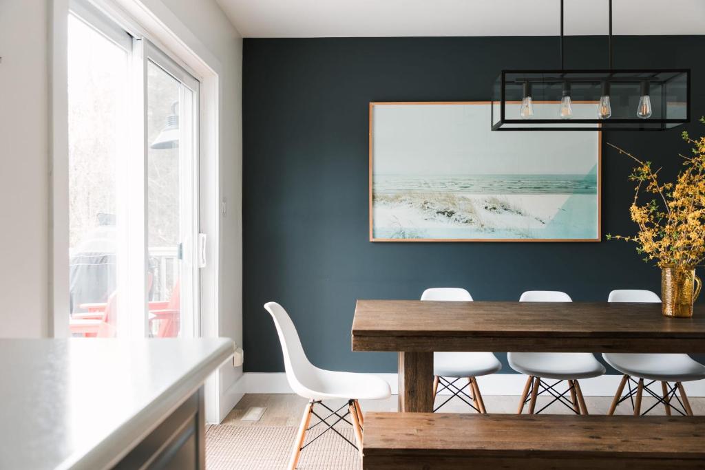 a dining room with blue walls and a wooden table and chairs at Woodland Chase in Wellington