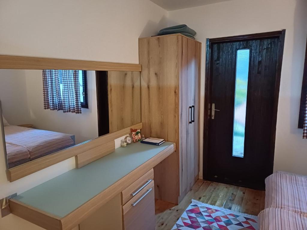 a bedroom with a mirror and a bed and a desk at WIN apartment in Plužine