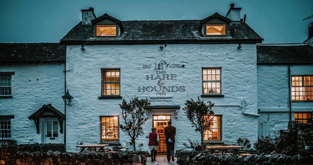 a man standing in front of a white building at The Hare & Hounds Inn in Bowland Bridge