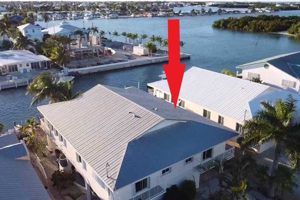 an aerial view of a house with a red arrow on it at Easy Ocean Access 30' Dock - House - Private Club w/ Heated Pool and Sandy Beach in Key Colony Beach