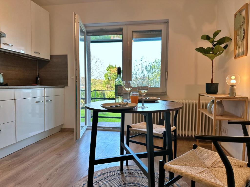 - une cuisine avec une table et des verres à vin dans l'établissement Garten-Blick-Baldeneysee, à Essen