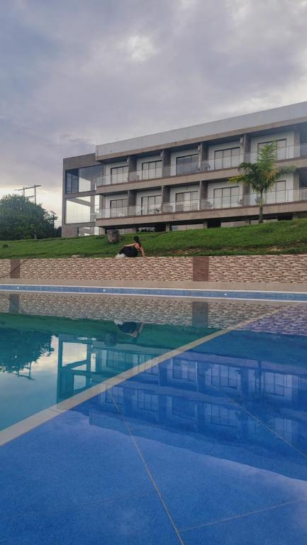 a building with a swimming pool in front of a building at Guayupes Hotel de Aventura in Guamal