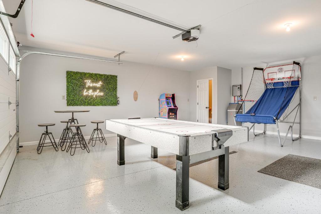 a room with a ping pong table and chairs at Benton Harbor Home with Fire Pit - 2 Mi to Beach! in Benton Harbor