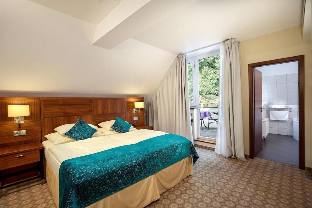 een slaapkamer met een groot bed en een badkamer bij Hotel Silenzio in Praag