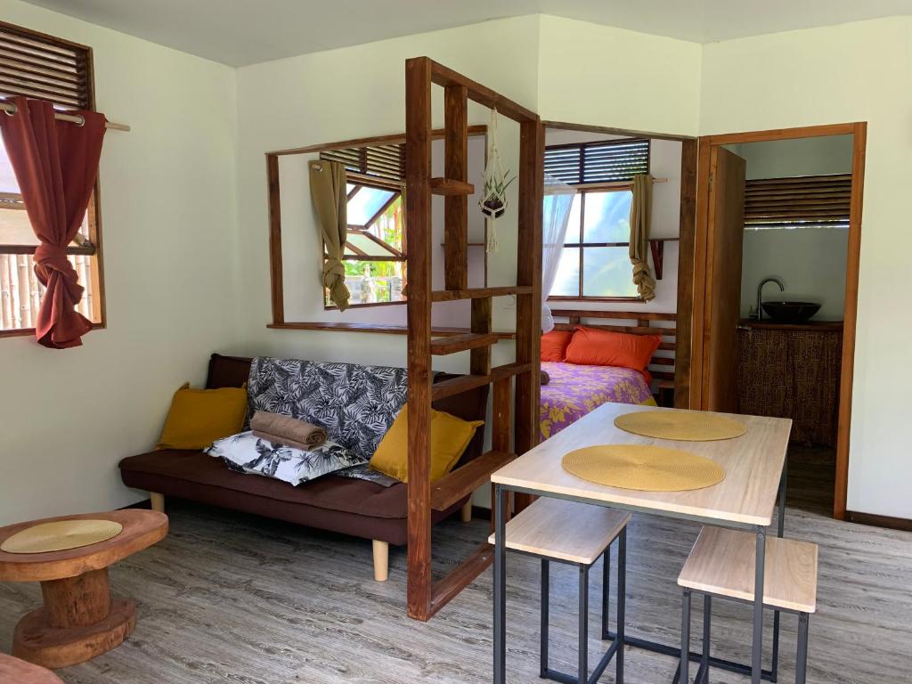 a living room with a bunk bed and a table at Fare lei , bungalow en toute simplicité in Uturoa
