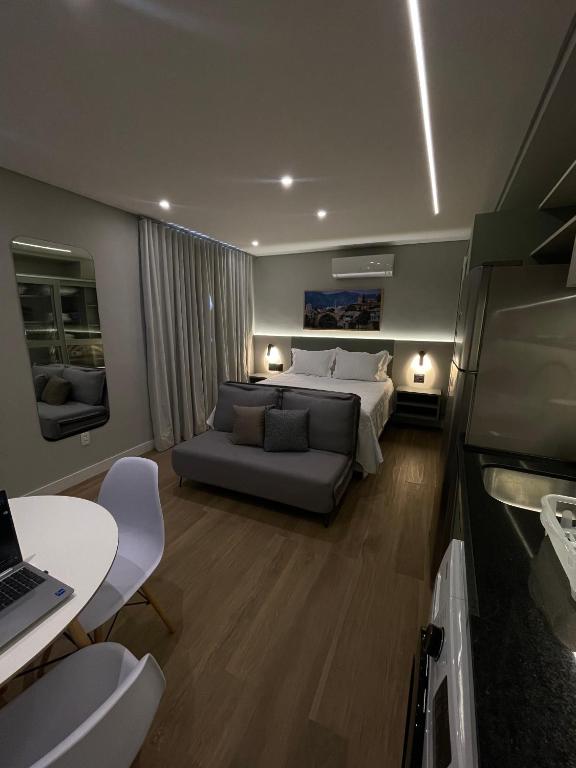 サンパウロにあるIguatemi Stay B - PREMIUM location, MODERN and NEW space, Affordableのベッドとソファとテーブルのある寝室