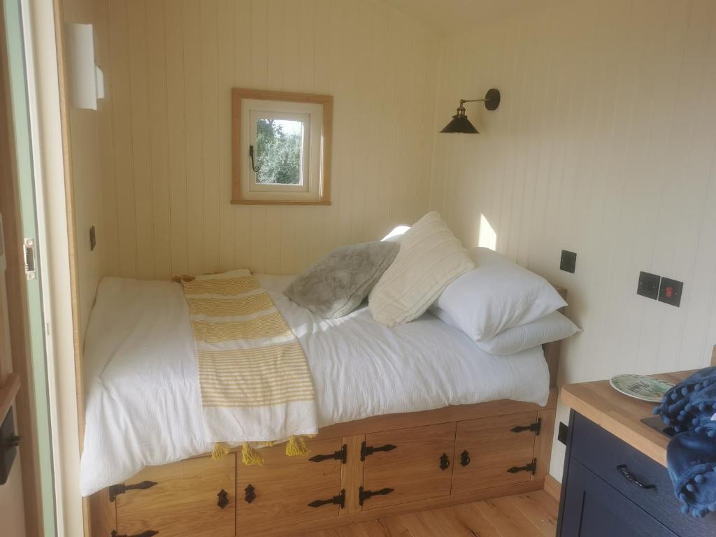 a bedroom with a bed with white sheets and pillows at Cwt y Mynydd in Chester