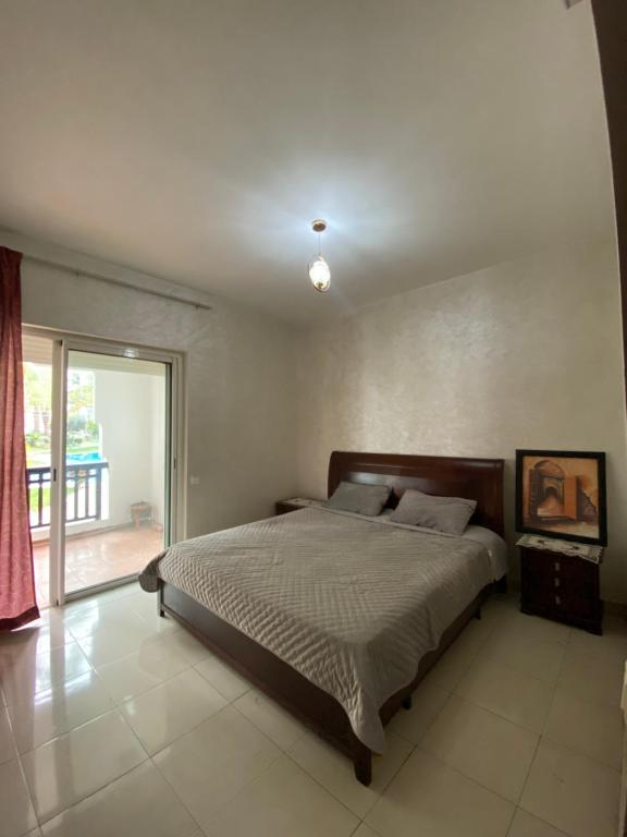 - une chambre avec un lit et une grande fenêtre dans l'établissement cozy apprtr, à Agadir