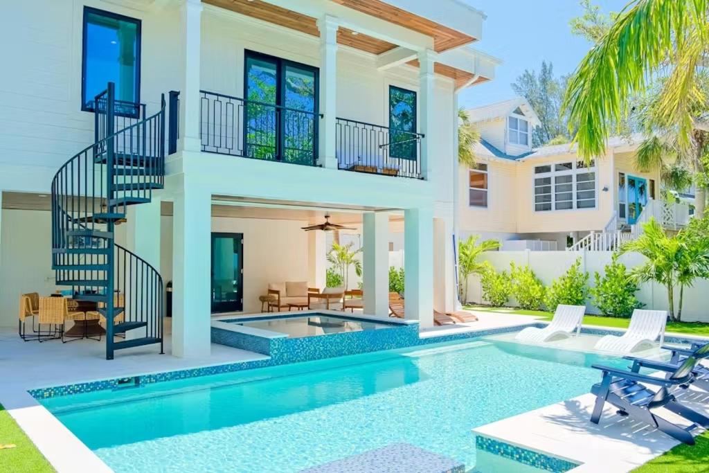 a villa with a swimming pool and a house at Tropical Gulf View Estate - Anna Maria, FL in Anna Maria