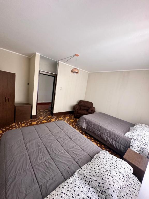 Un dormitorio con 2 camas y una silla. en CASTELLARES LA PUEBLA APARTAMENT, en Ayacucho