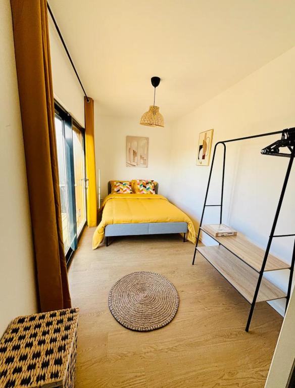 a bedroom with a yellow bed and a window at Evasion tropicale in Bretteville-sur-Odon