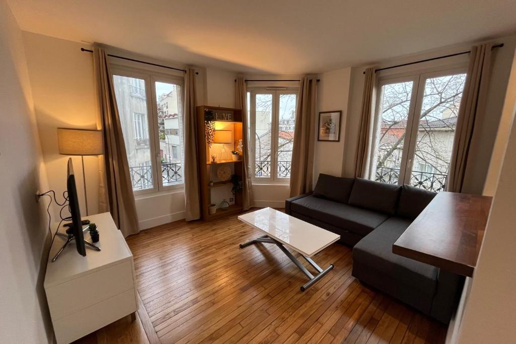 - un salon avec un canapé et une table dans l'établissement Elegant 1-bedroom completely renovated - Paris, aux Lilas