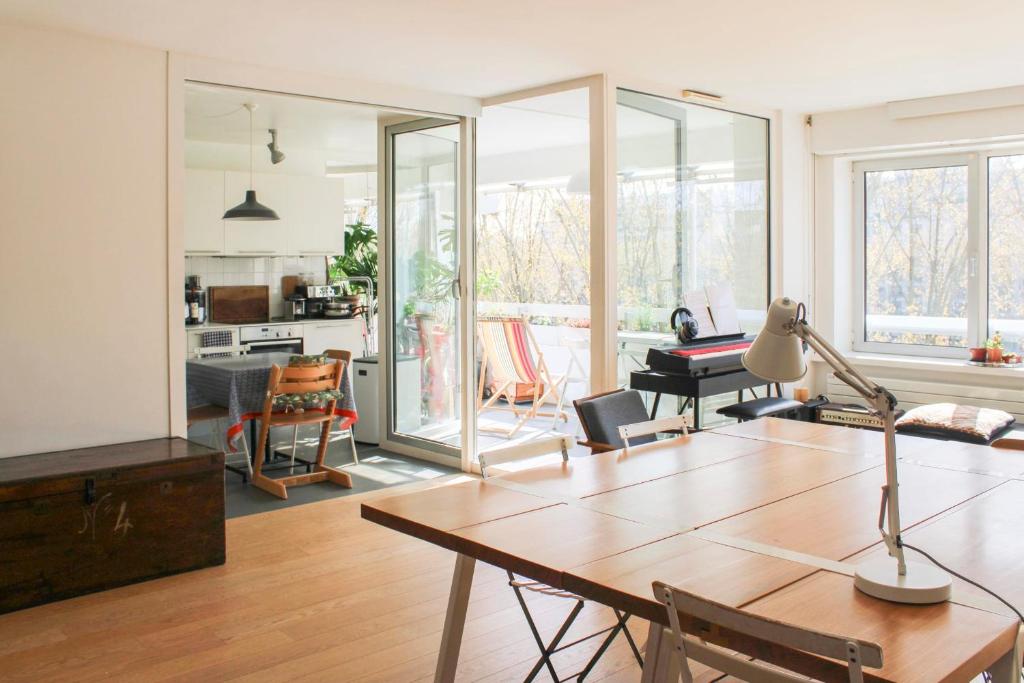 un salon avec une table et une salle à manger dans l'établissement Spacious cocoon with a terrace view on the canal, à Paris