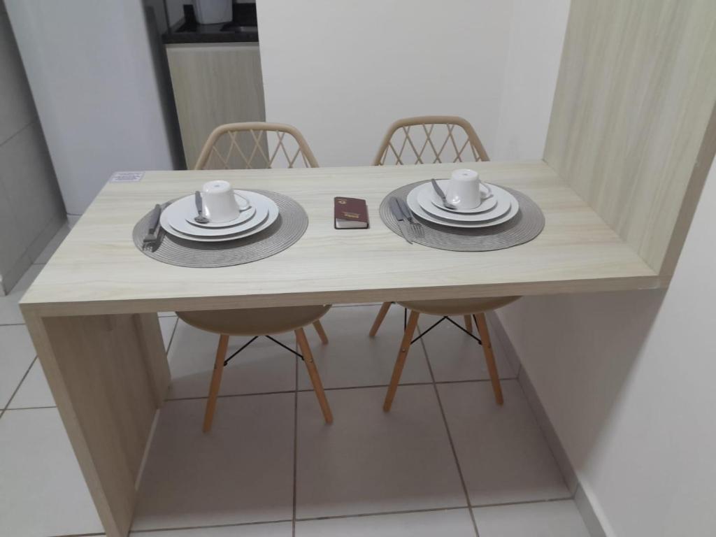 a table with two hats and two cups on it at Apt Completo no West Flat in Mossoró