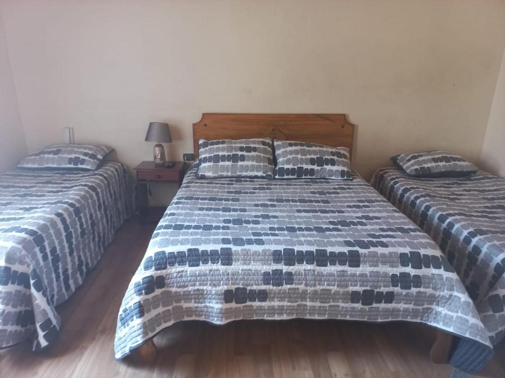 a bedroom with two beds with blue and white sheets at Ovalle Hotel Arauco in Ovalle