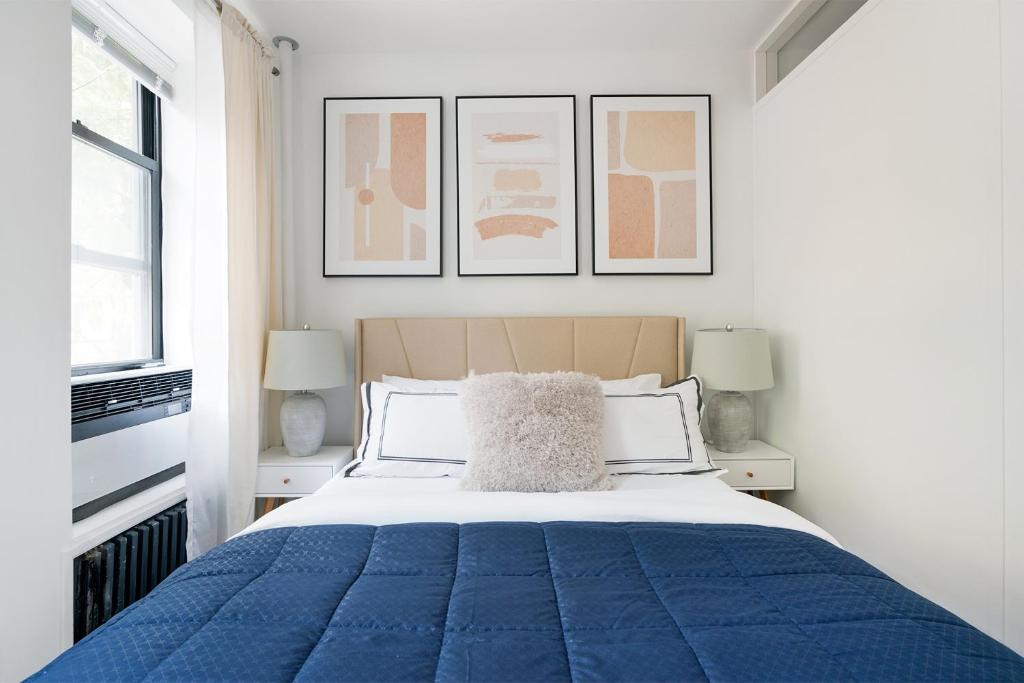 紐約的住宿－444-2C Newly renovated 1BR in Hell's Kitchen，一间卧室配有一张带两盏灯的蓝色床。