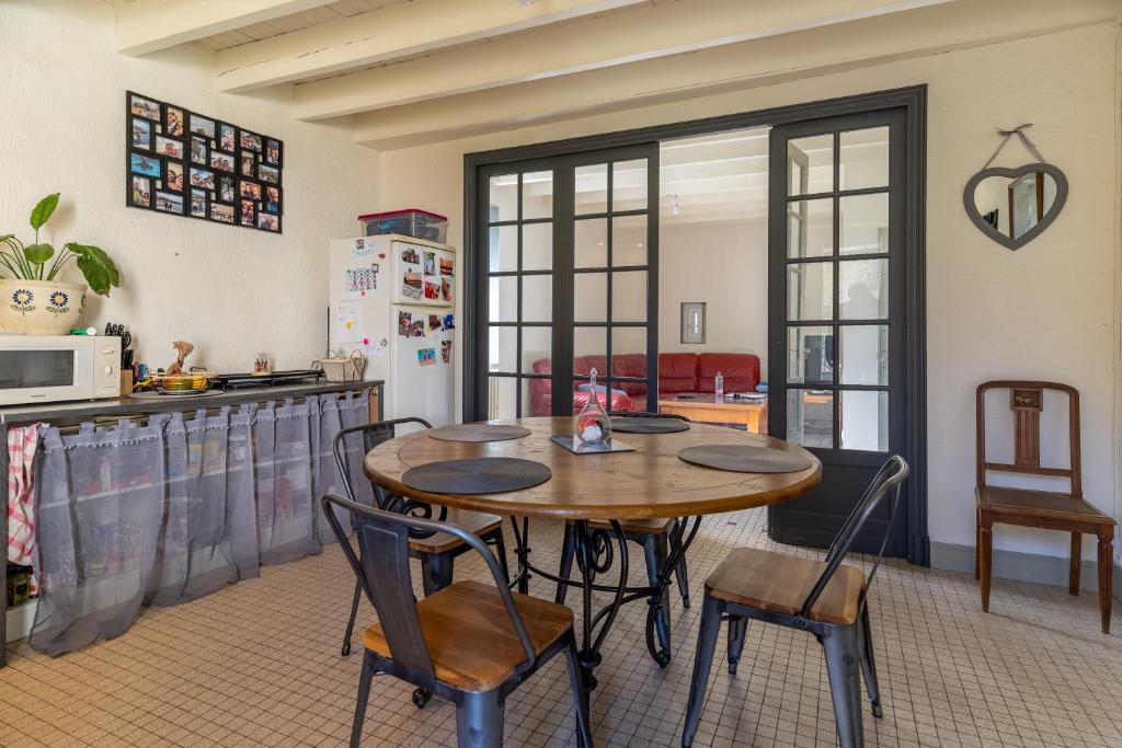 uma cozinha com mesa e cadeiras num quarto em Le jardin de Mia em Aiguefonde