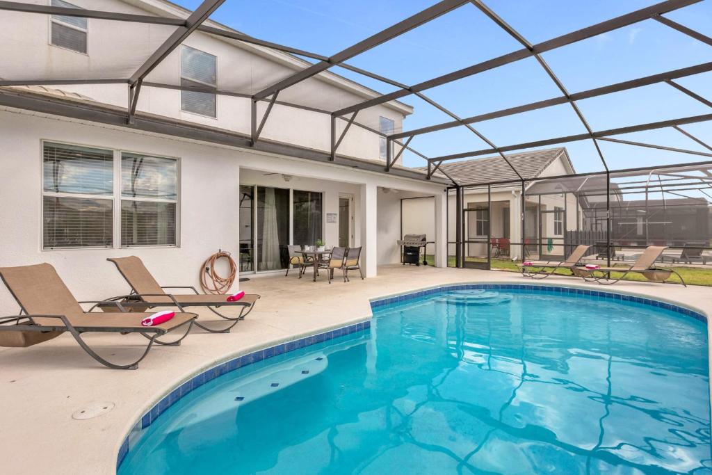 an indoor swimming pool with a glass roof over it at Upstay - Sonoma Resort Home w Private Pool in Kissimmee