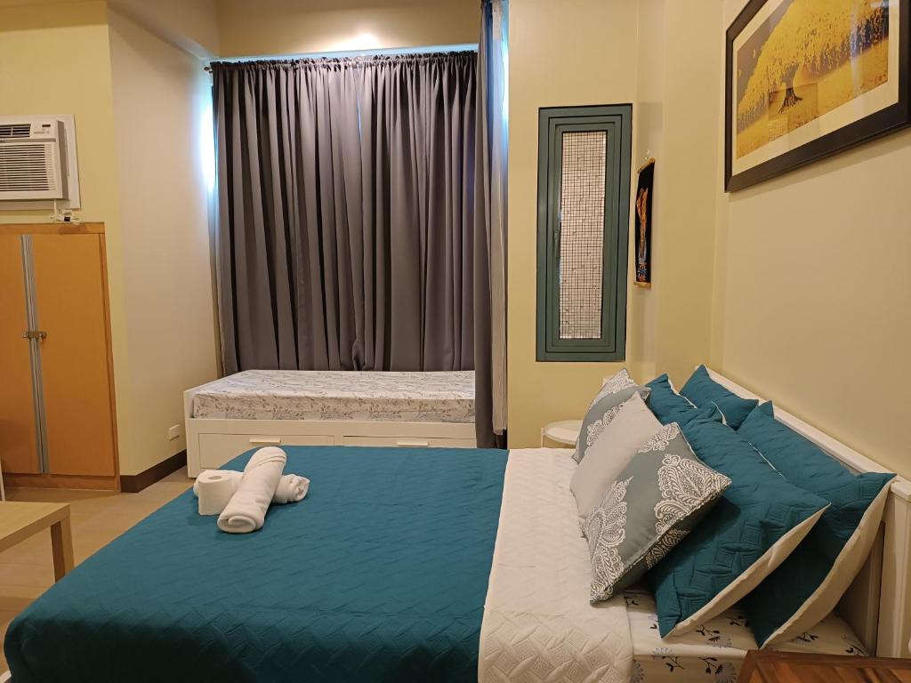 - une chambre avec un lit et des serviettes dans l'établissement Rj Condotel Near Naia Terminal 3, à Manille