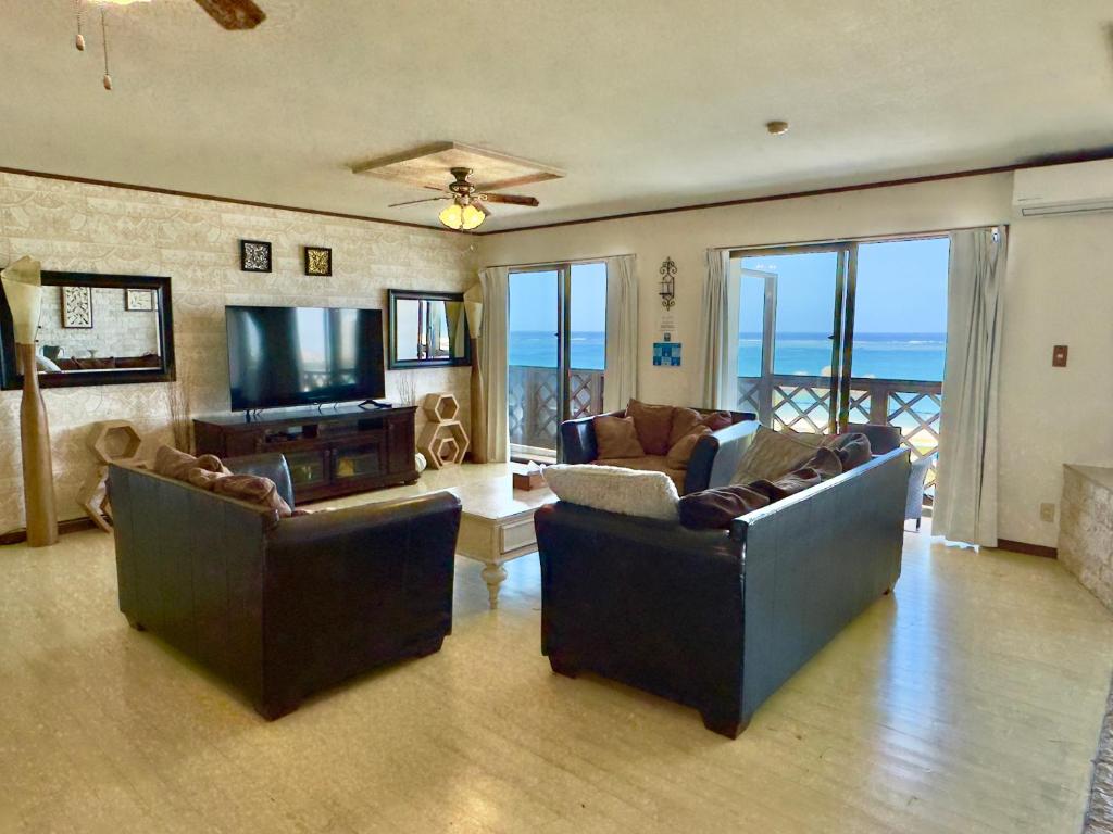 a living room with two couches and a flat screen tv at Araha Resort Arapana in Chatan