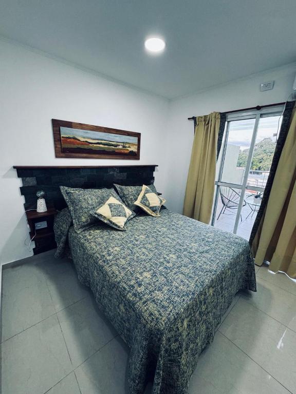 a bedroom with a bed with pillows and a window at Departamento BELGRANO CENTRO in Paraná