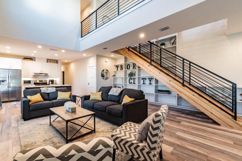 a living room with two couches and a staircase at The Roosted Retreat in Tampa