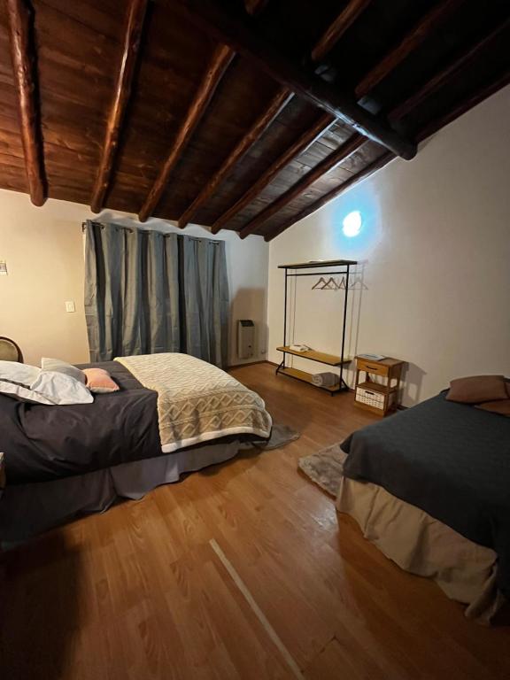 1 dormitorio con 2 camas y suelo de madera en Trono de Nubes en Trevelín