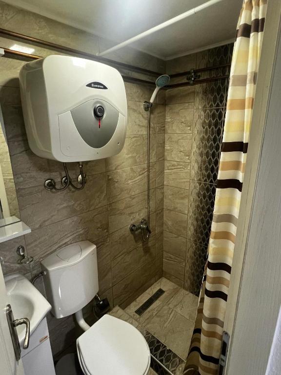 a small bathroom with a toilet and a shower at Hostel Tuzla in Tuzla