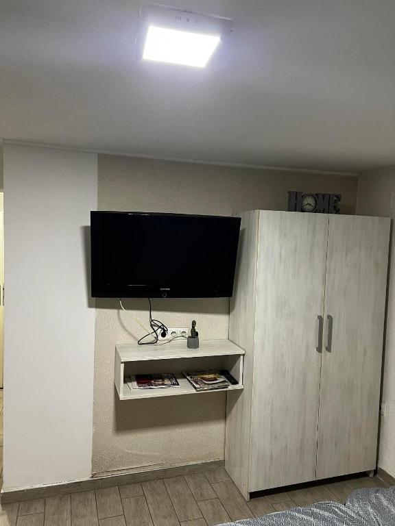 a living room with a tv and a white cabinet at Hostel Tuzla in Tuzla