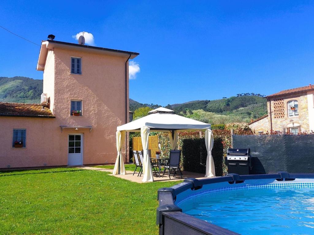 einen Pool mit Pavillon neben einem Haus in der Unterkunft Casina di Andrea with above ground pool, Capannori in Capannori