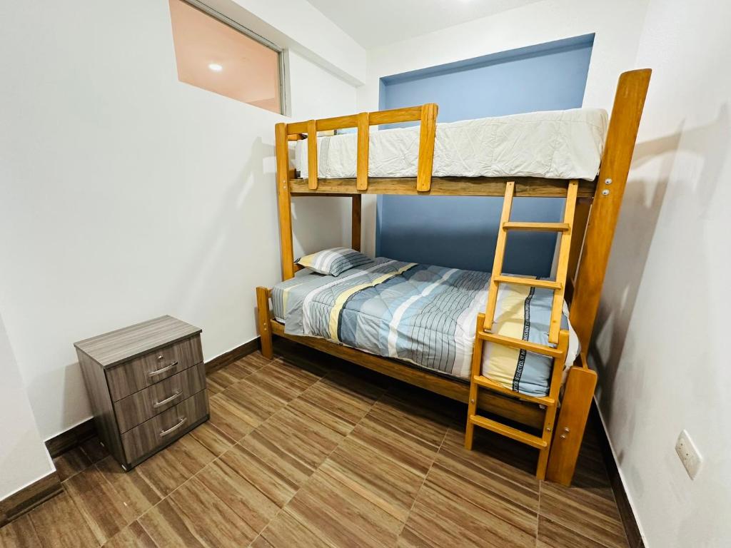 a bedroom with two bunk beds and a ladder at Kayac Hostel in Huaraz