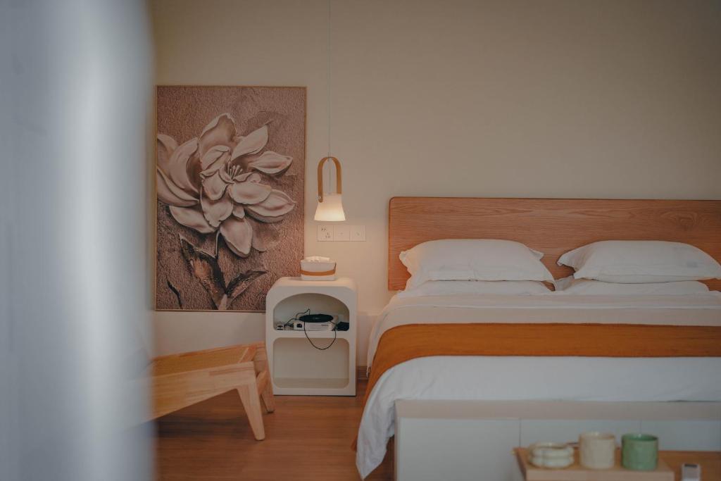sypialnia z łóżkiem i obrazem na ścianie w obiekcie Leye Inn w mieście Yangshuo