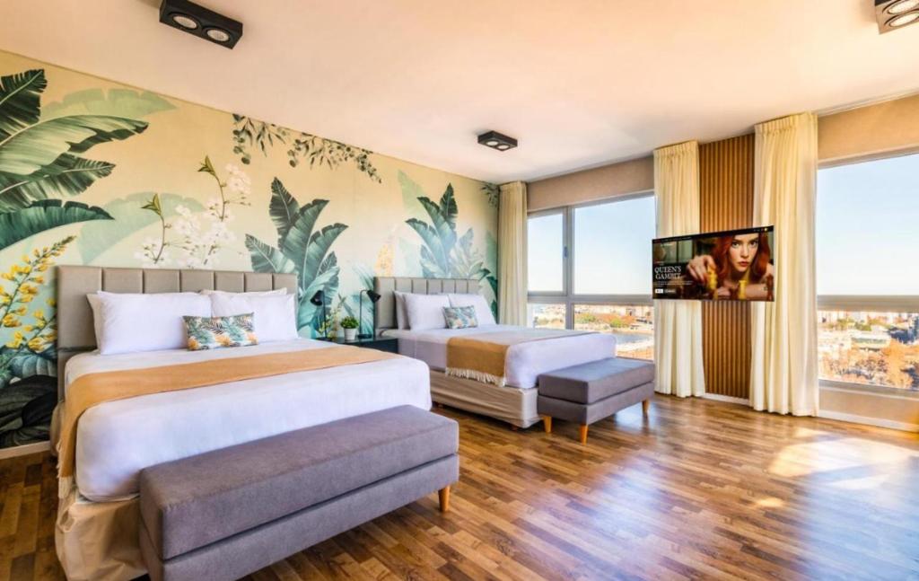 a bedroom with two beds and a flat screen tv at jerusalemvip in El Muṣrāra