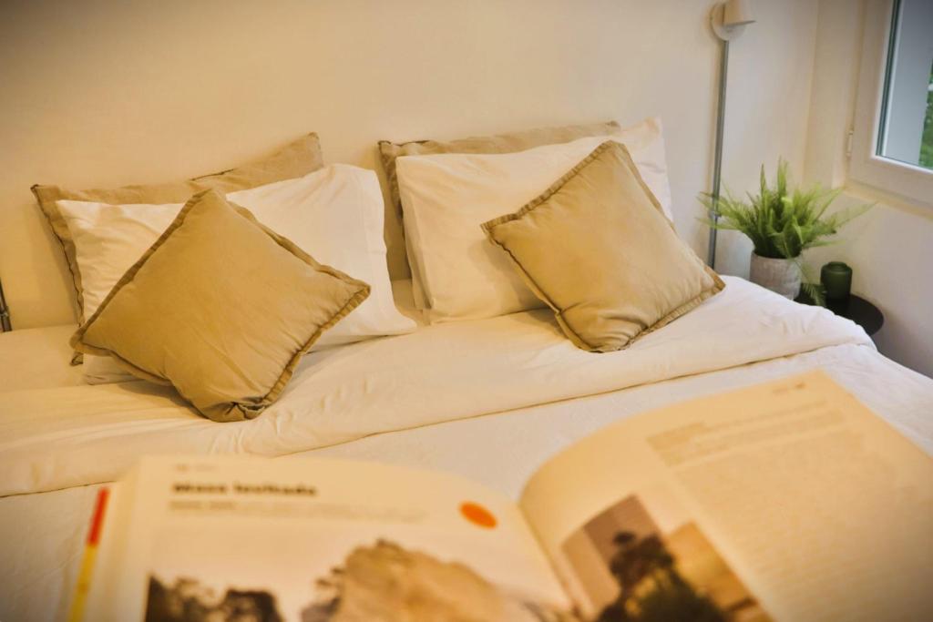 a bed with pillows and a book on it at Luminoso Studio en Santiago Centro HOM in Santiago