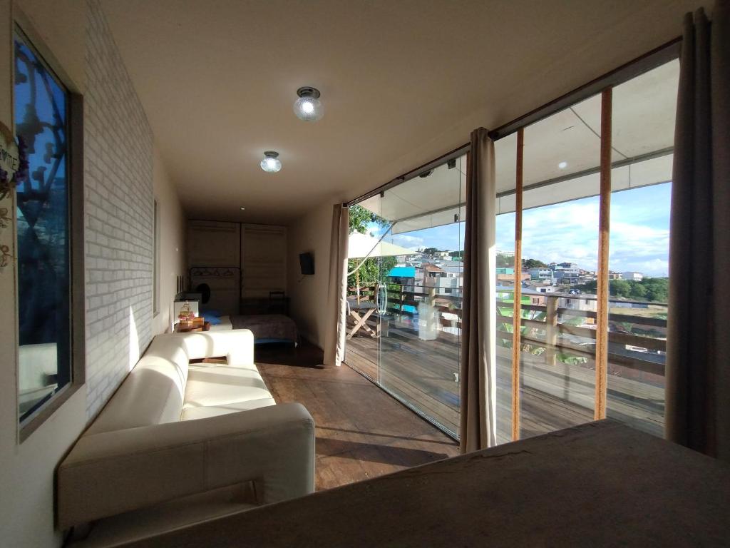 a living room with a couch and a large window at Recanto das Pedras - Loft Container in São Thomé das Letras