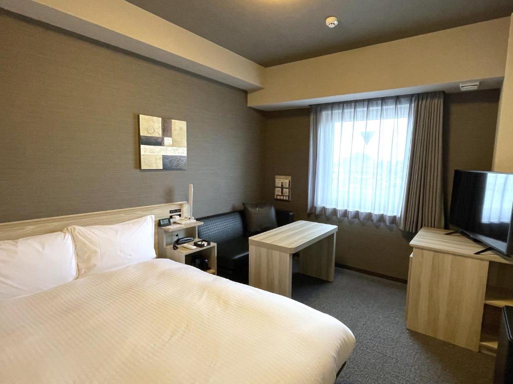 Postel nebo postele na pokoji v ubytování Hotel Route Inn Ohi Takahama