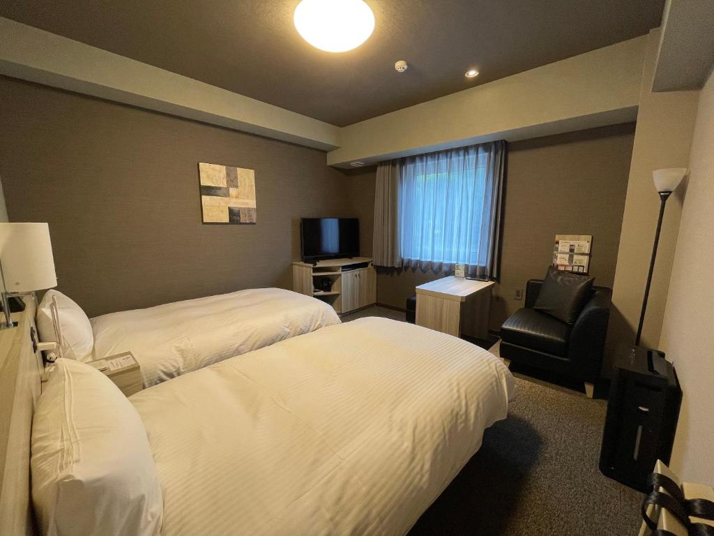 Postel nebo postele na pokoji v ubytování Hotel Route Inn Ohi Takahama