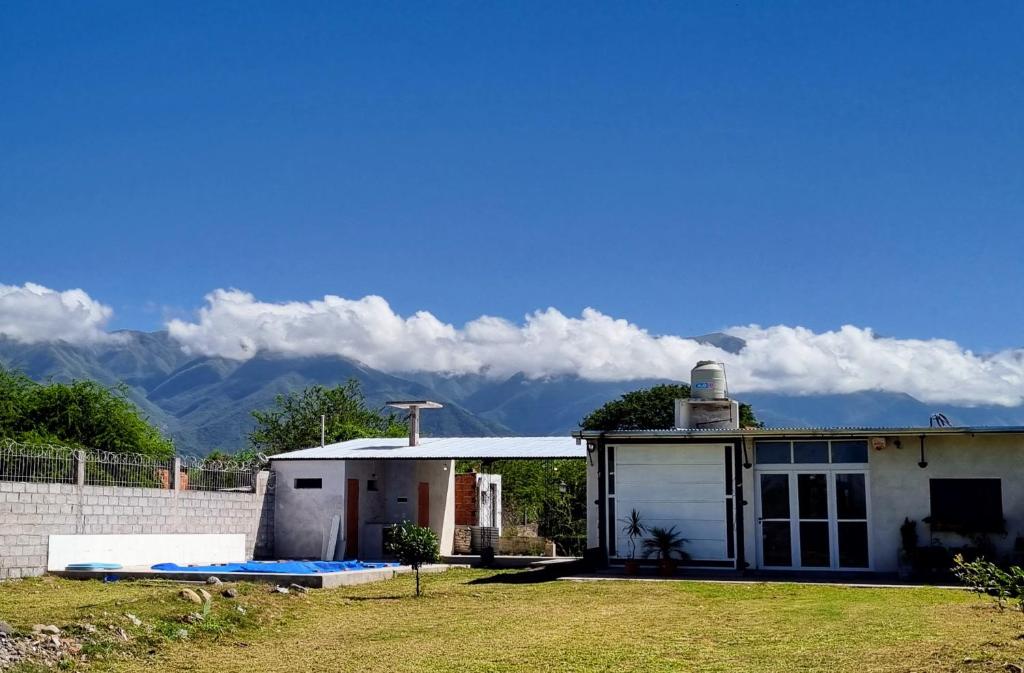 a small white house with mountains in the background at El Descanso Silletano in La Silleta