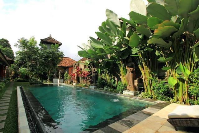 a swimming pool in the yard of a house at Bale Bali Inn in Ubud