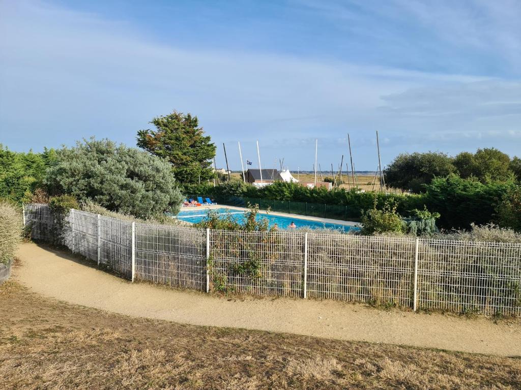 a fence in front of a swimming pool at Appartement Arzon, 2 pièces, 5 personnes - FR-1-639-17 in Arzon
