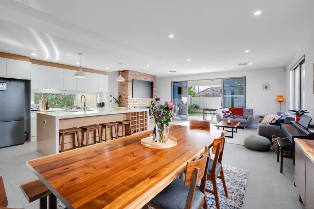 a kitchen and living room with a wooden table at Modern 3 BR home in Fulham in Henley Beach South